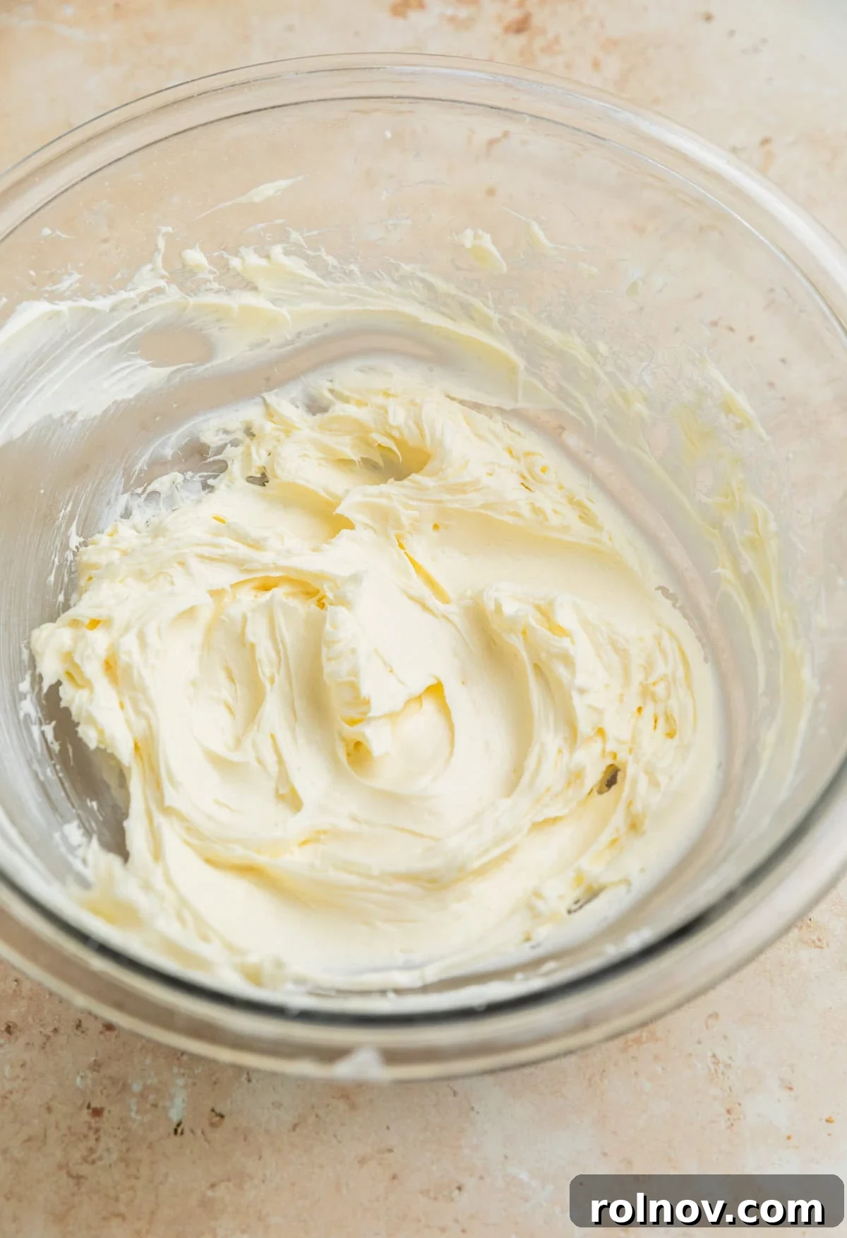 Dreamy Blueberry Cheesecake Dip 4 Creamed softened cream cheese and powdered sugar being mixed in a deep mixing bowl with a hand mixer, ensuring a smooth base.