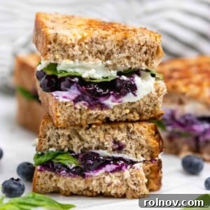 Sweet & Savory Blueberry Basil Goat Cheese Grill 8 Stacked grilled goat cheese sandwich on counter with blueberries and basil.