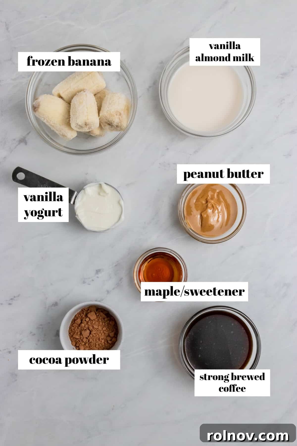 Banana, coffee, peanut butter and smoothie ingredients on counter.