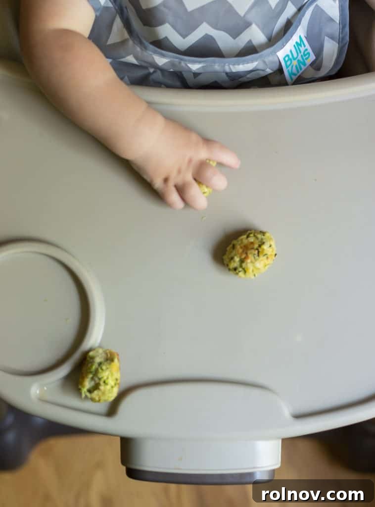Zucchini Cheese Poppers 3 Adorable baby Sam enjoying his Cheesy Zucchini Tots, promoting healthy eating for toddlers.
