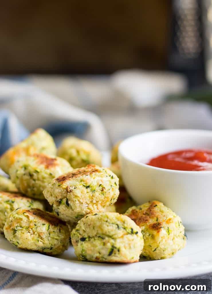 Zucchini Cheese Poppers 5 A plate of homemade Cheesy Zucchini Tots, ideal healthy snack for toddlers and a great way to incorporate vegetables into family meals.