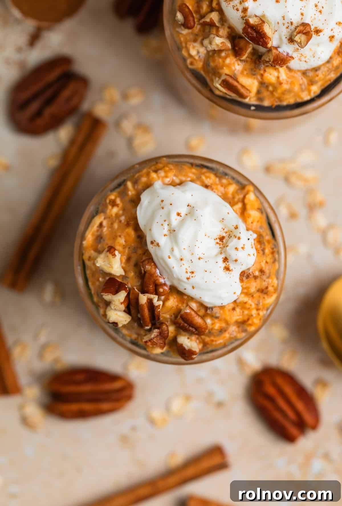 Spiced Pumpkin Overnight Oats 3 Overhead view of overnight oatmeal in jars with whipped cream and cinnamon topping.