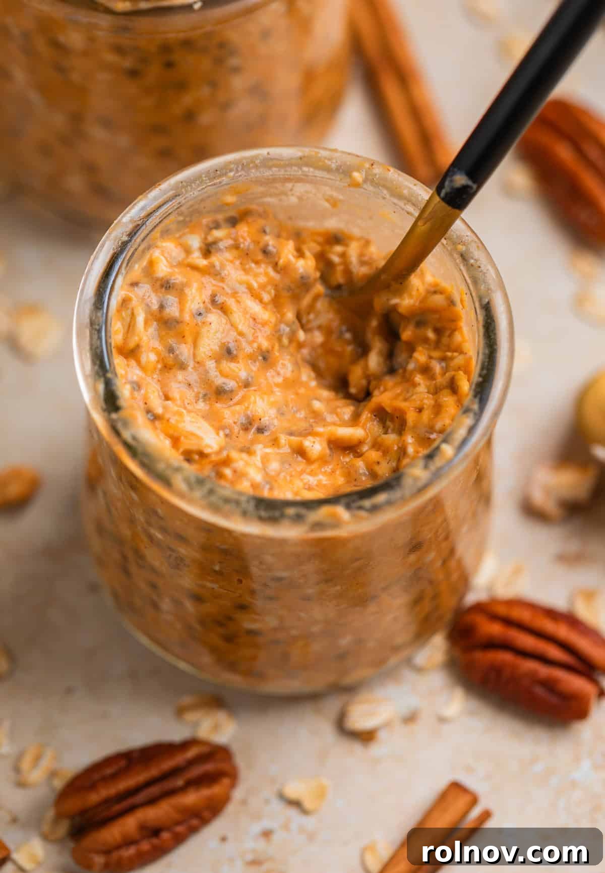 Spiced Pumpkin Overnight Oats 4 Jar with spoon scooping into pumpkin oatmeal.