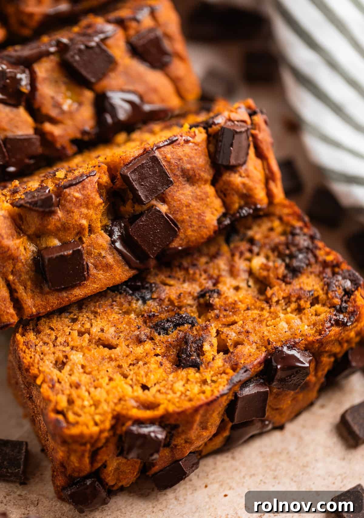 Pumpkin Speckled Banana Bread 8 Sliced of banana bread with dark chocolate chips layered at a slant.