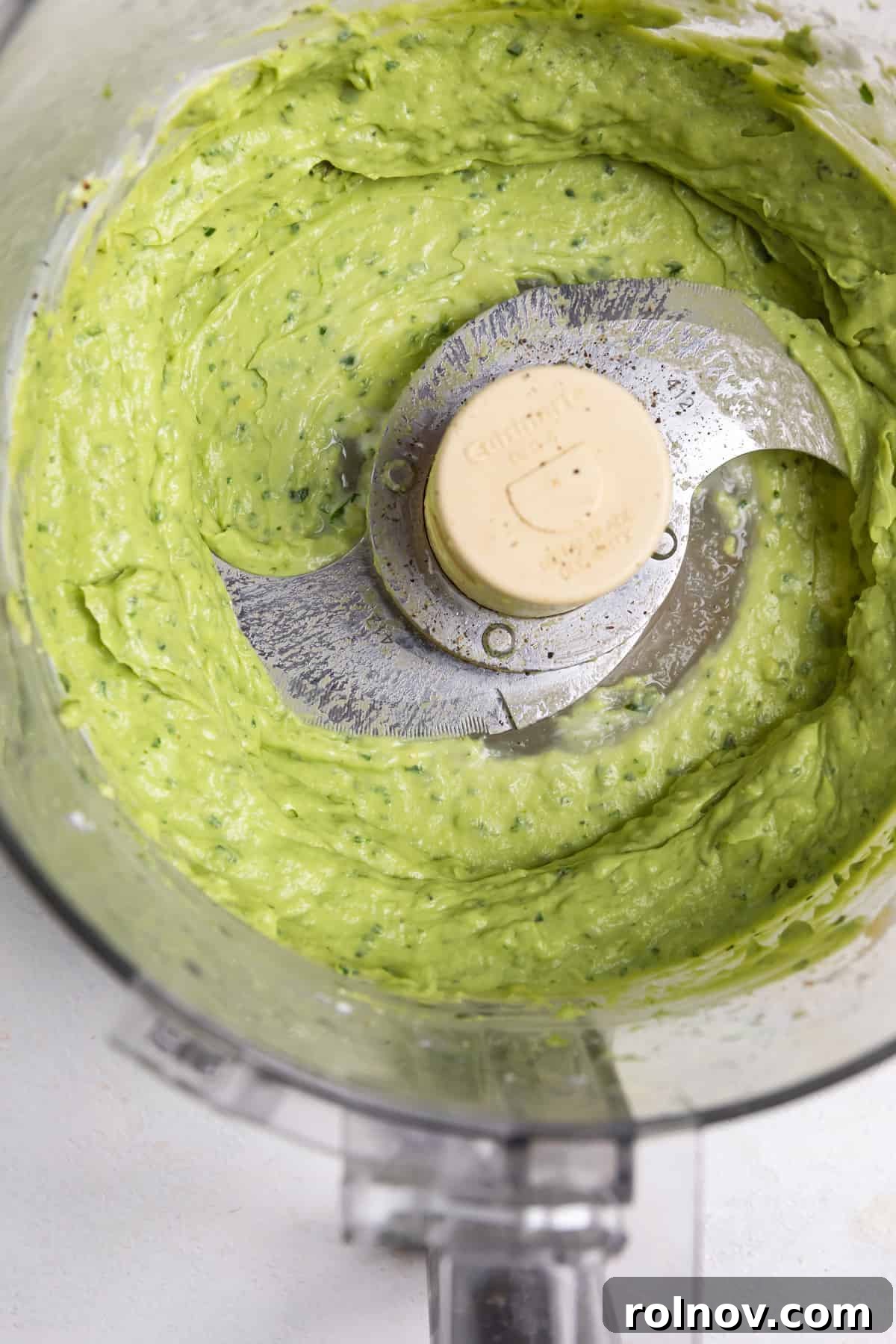 Creamy avocado crema in a food processor, ready to be blended.