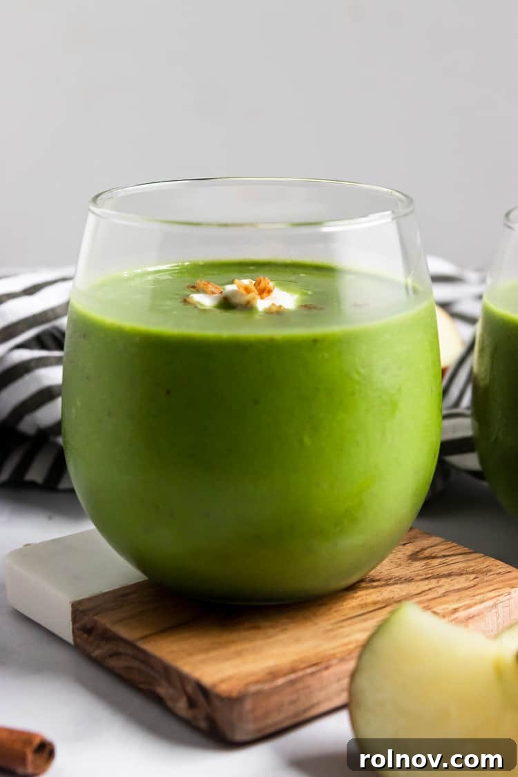 Green Dream Apple Pie Smoothie 3 A single glass of vibrant green apple smoothie, perfectly blended and ready to enjoy, highlighting its smooth texture.