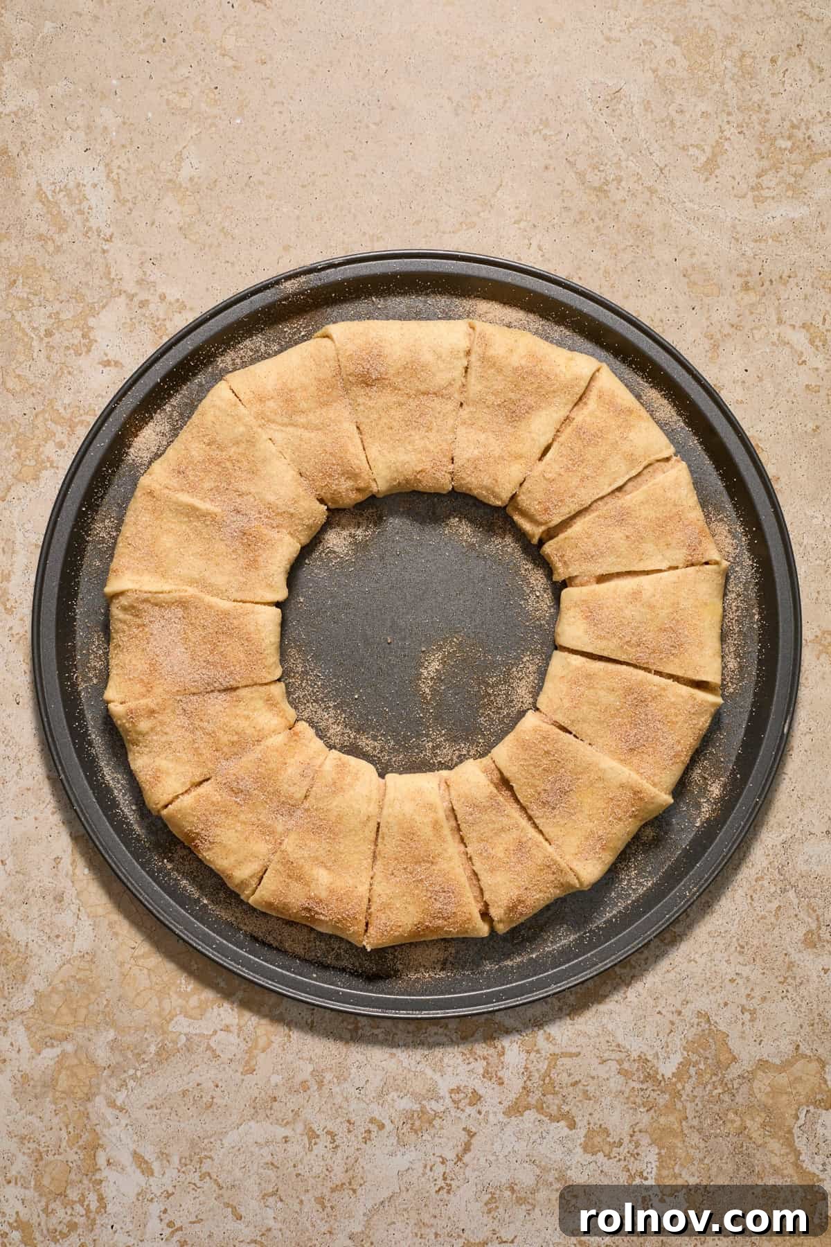 Cinnamon and sugar sprinkled over top of dough formed into circle.