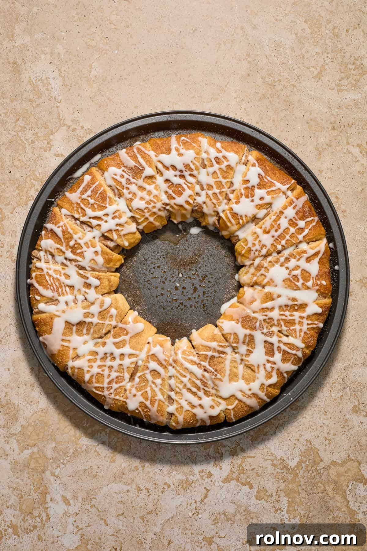 Baked cinnamon cream cheese pastry on pan freshly iced.