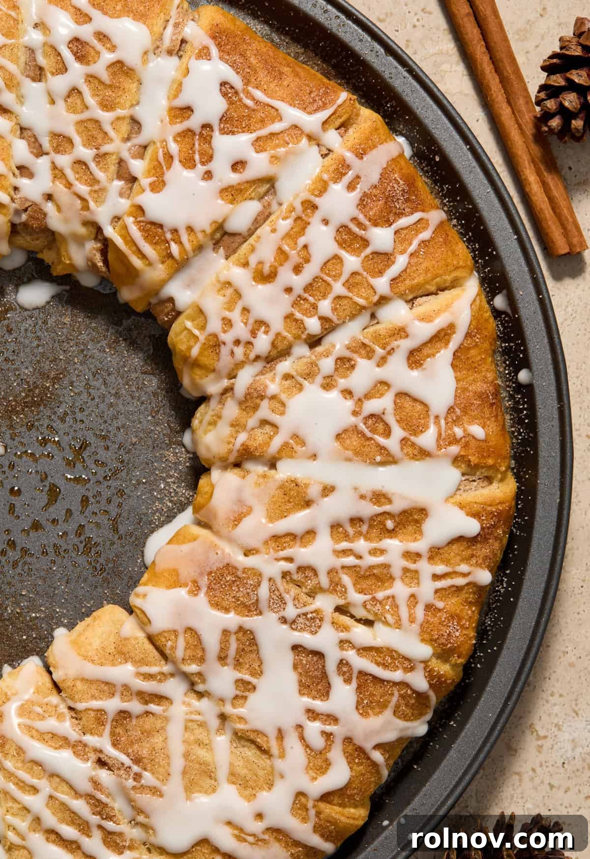 Close up view of cinnamon crescent wreath with icing drizzle over top, showcasing the filling.