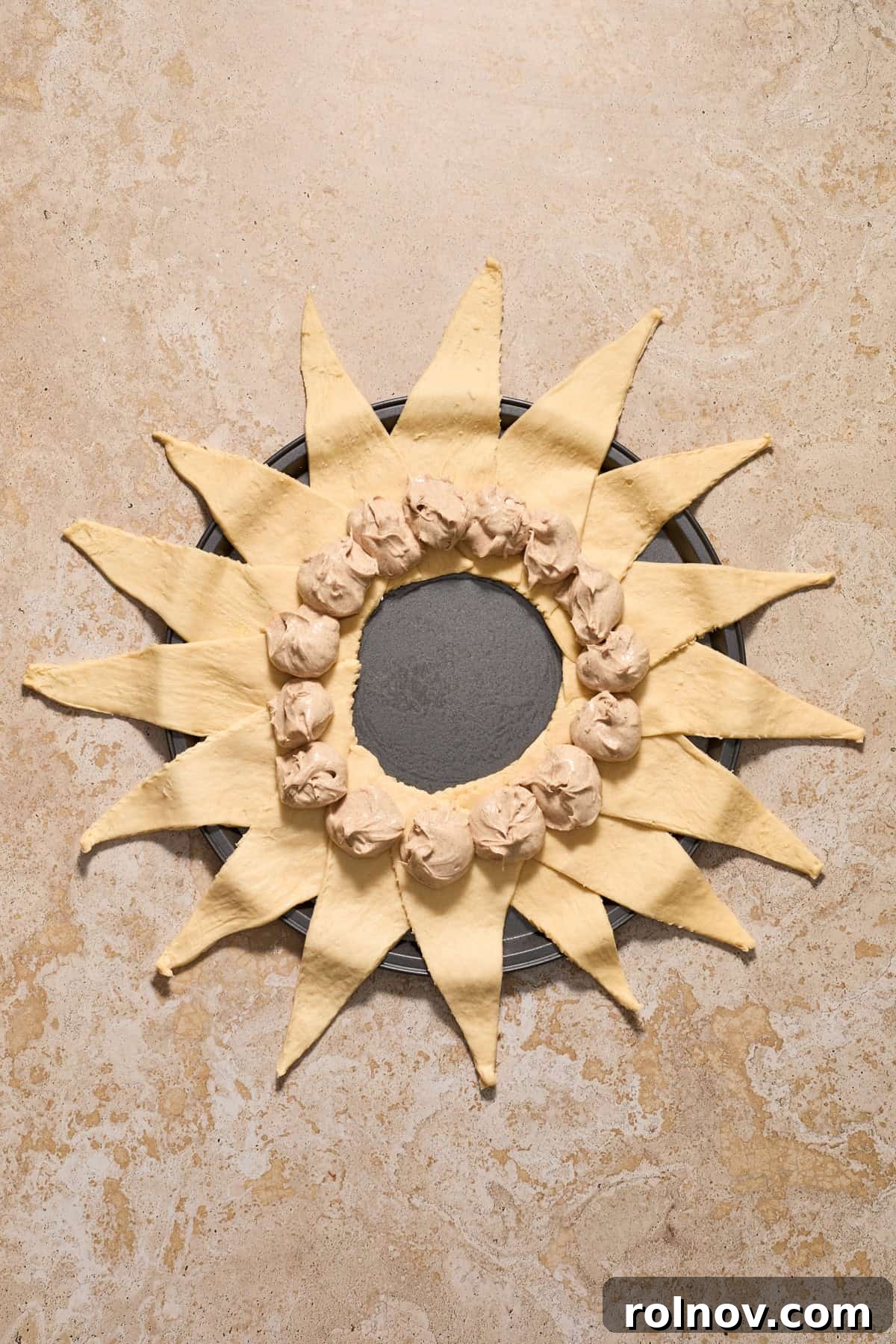 Cinnamon cream cheese mixture spooned into the center of crescent triangles arranged to form a circle.