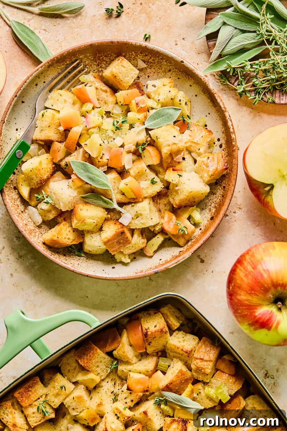 Homestyle Apple Sage Stuffing 14 A single serving of apple sage bread stuffing on a white plate with the baking pan in the background.