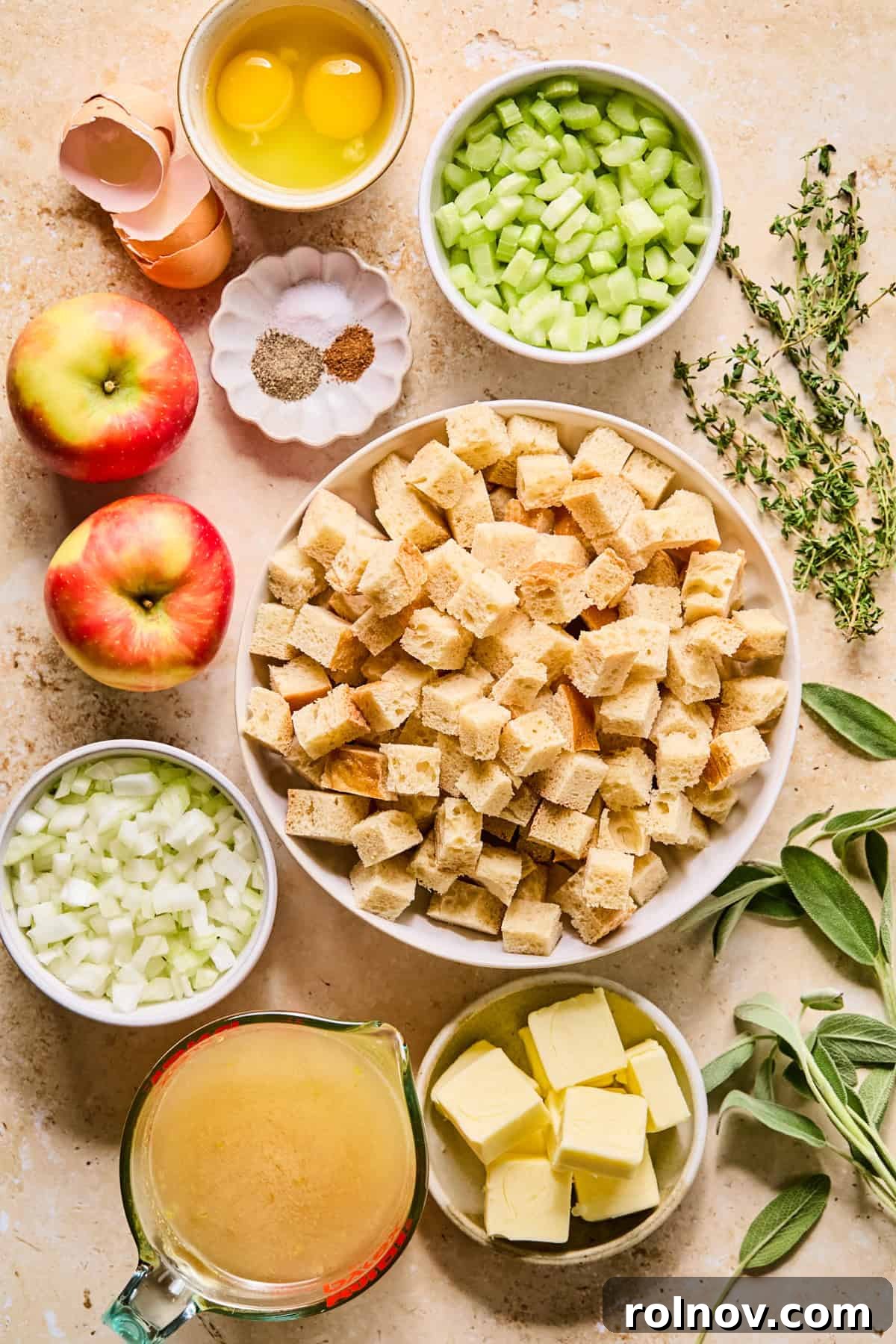 Homestyle Apple Sage Stuffing 4 Fresh ingredients laid out for apple sage stuffing, including bread, apples, celery, onion, and herbs.