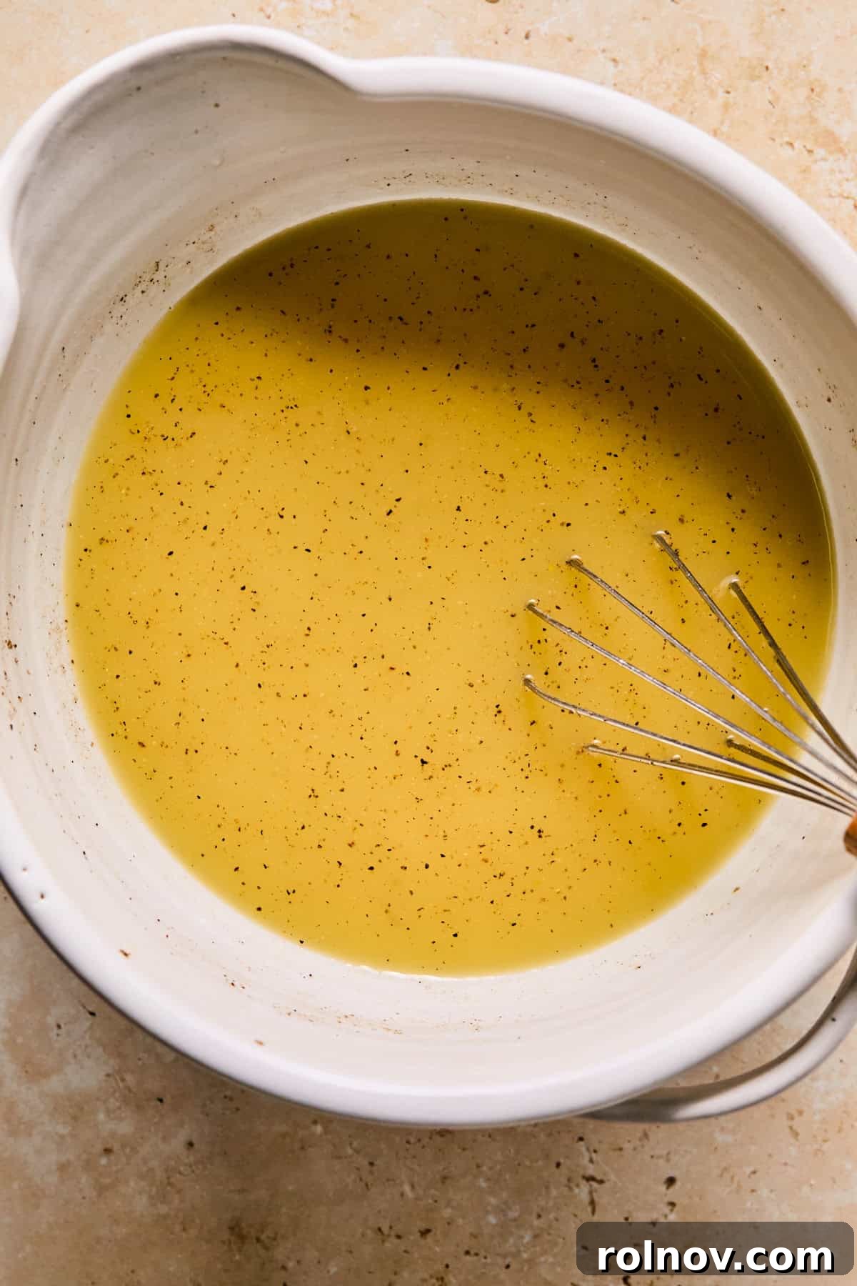 Homestyle Apple Sage Stuffing 8 Whisked mixture of chicken broth, eggs, nutmeg, salt, and pepper in a bowl.