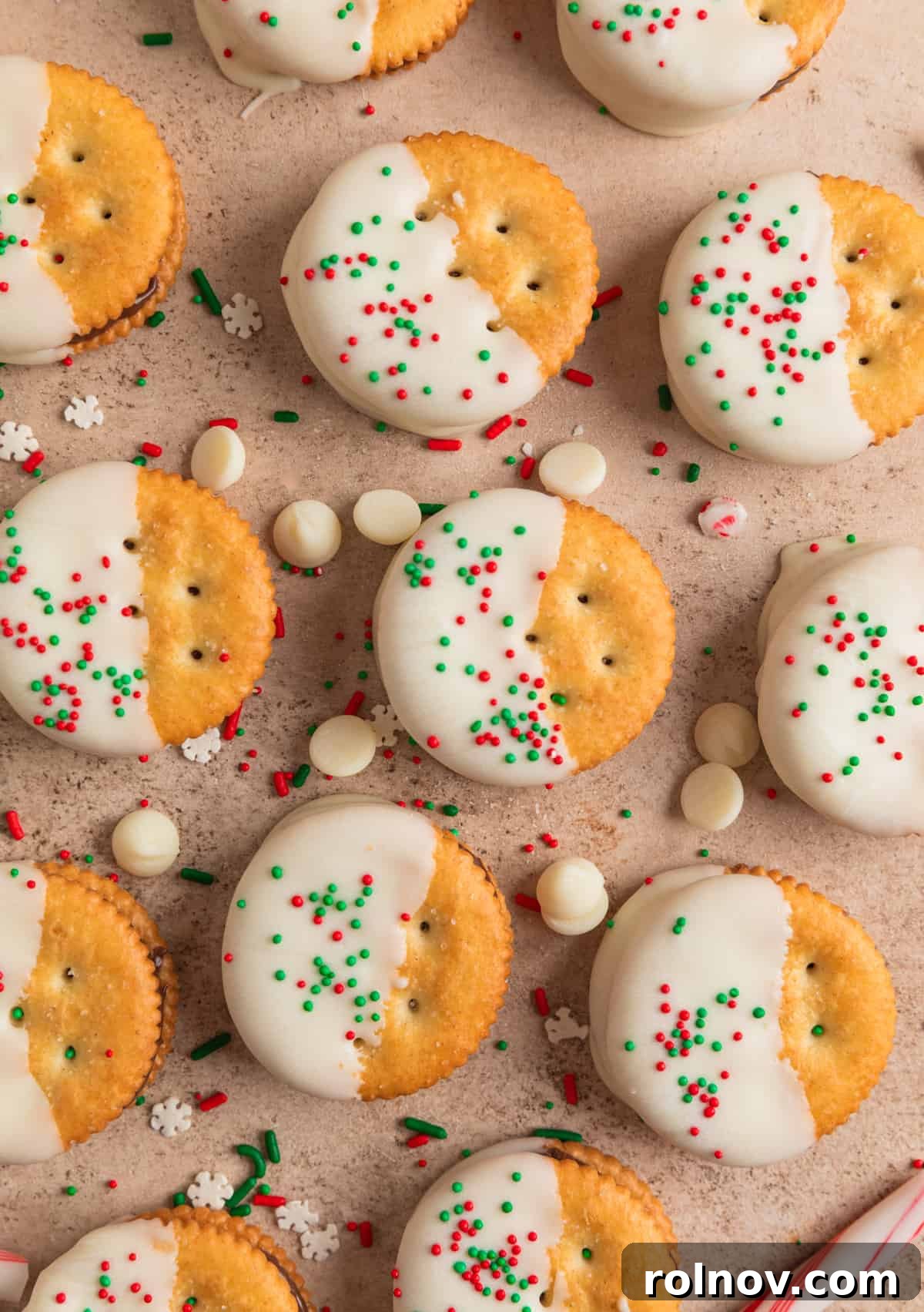 Christmas Ritz cracker cookies dipped in white chocolate and arranged on surface.