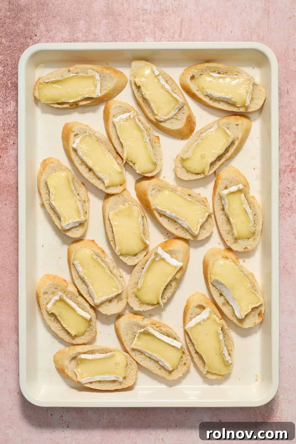 Golden-brown baguette slices with perfectly melted brie, fresh from the oven, ready for topping.