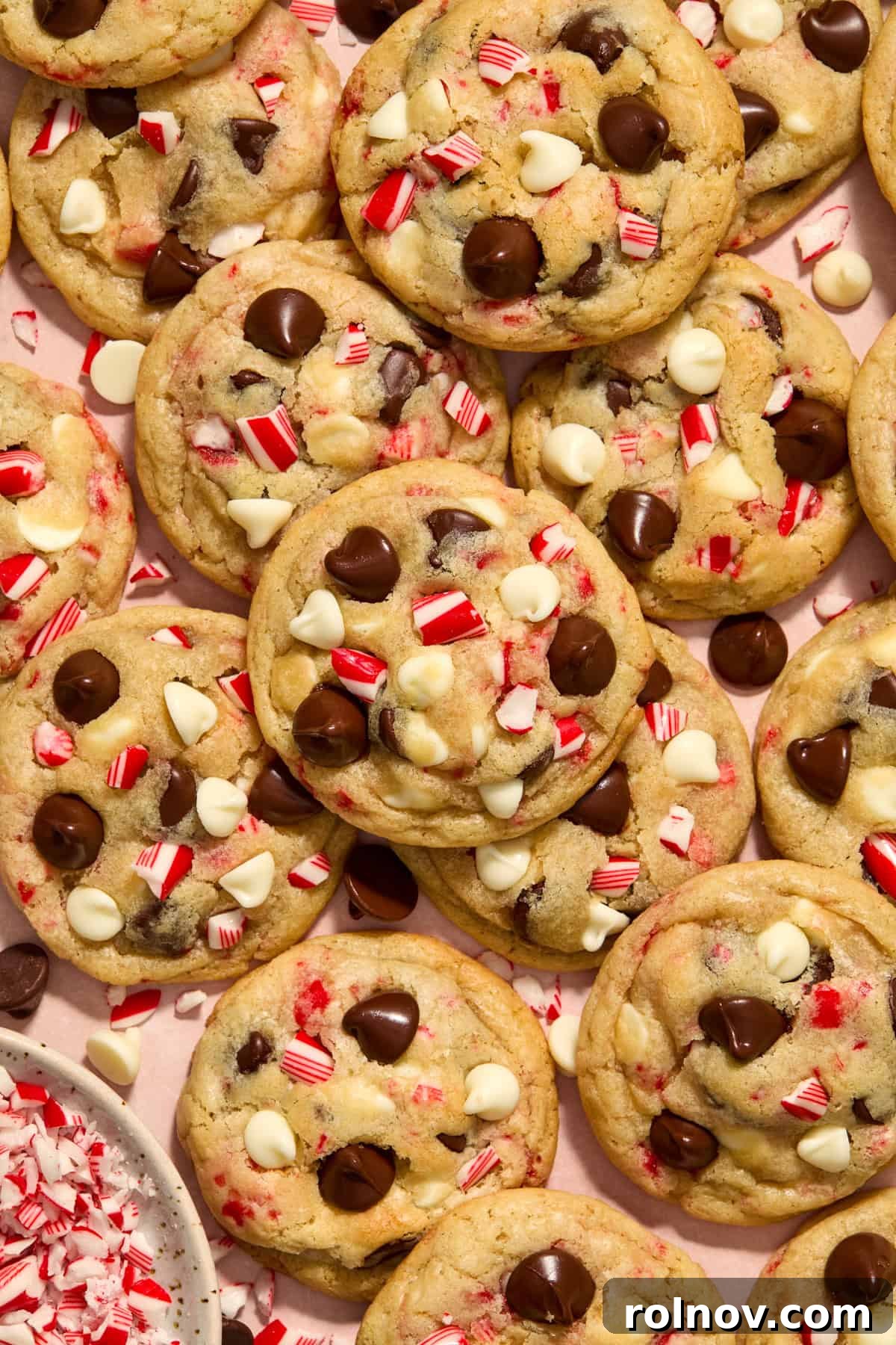 Cool Peppermint Chocolate Chip Cookies 2 Peppermint chip cookies arranged on a festive surface with chopped candy canes in a small bowl, ready for holiday enjoyment.