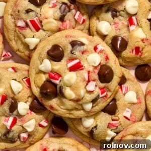 Peppermint chocolate chip cookies with white and dark chocolate chips and candy canes arranged on a plate, ready to be enjoyed.