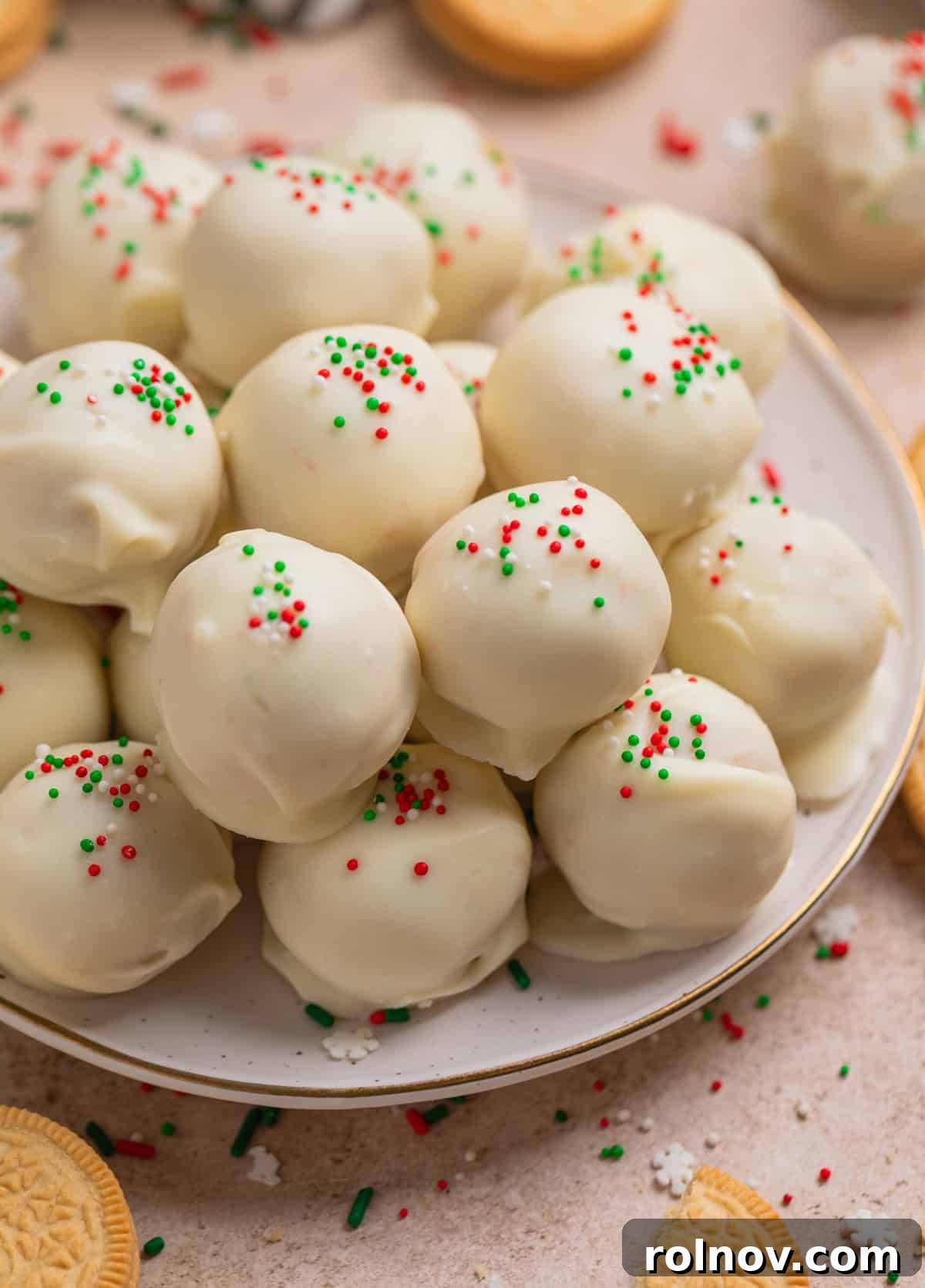 Christmas Oreo truffles covered in white chocolate and red and green sprinkles arranged on plate.