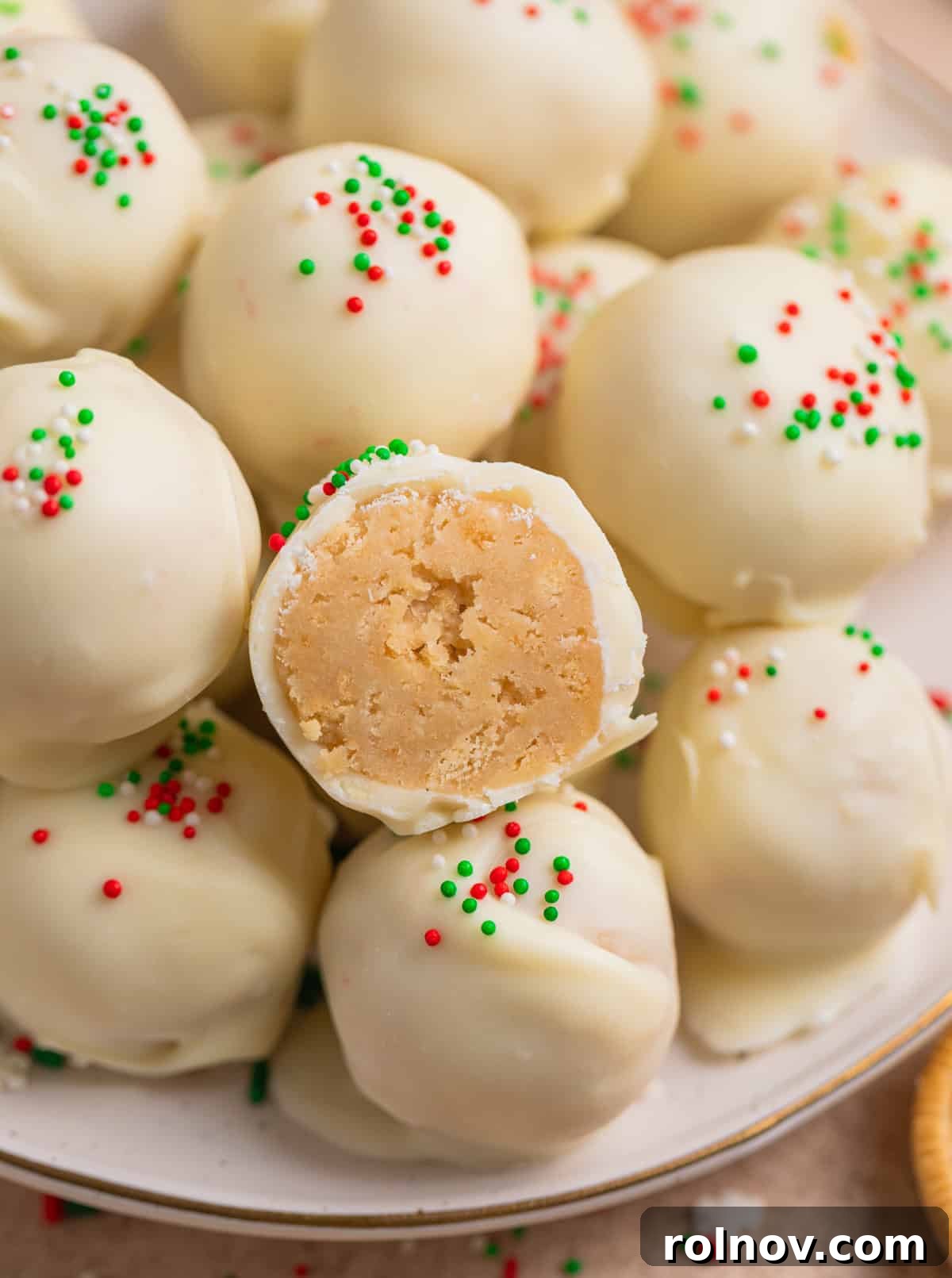Golden Oreo truffles on plate with bite taken out of one to show inside texture.