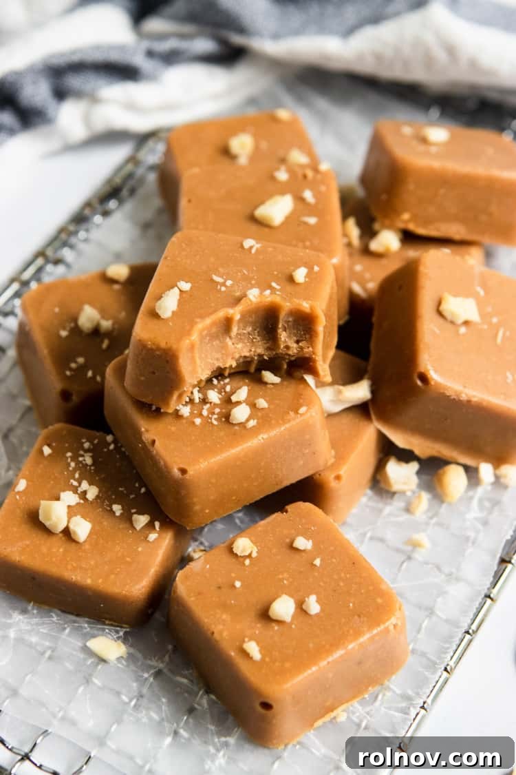 Various bite-sized pieces of Maple Cashew Freezer Fudge artfully arranged on a rustic wooden board.