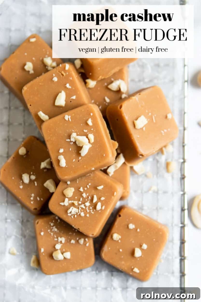 Close-up of a hand holding a single piece of Maple Cashew Freezer Fudge, highlighting its creamy texture.