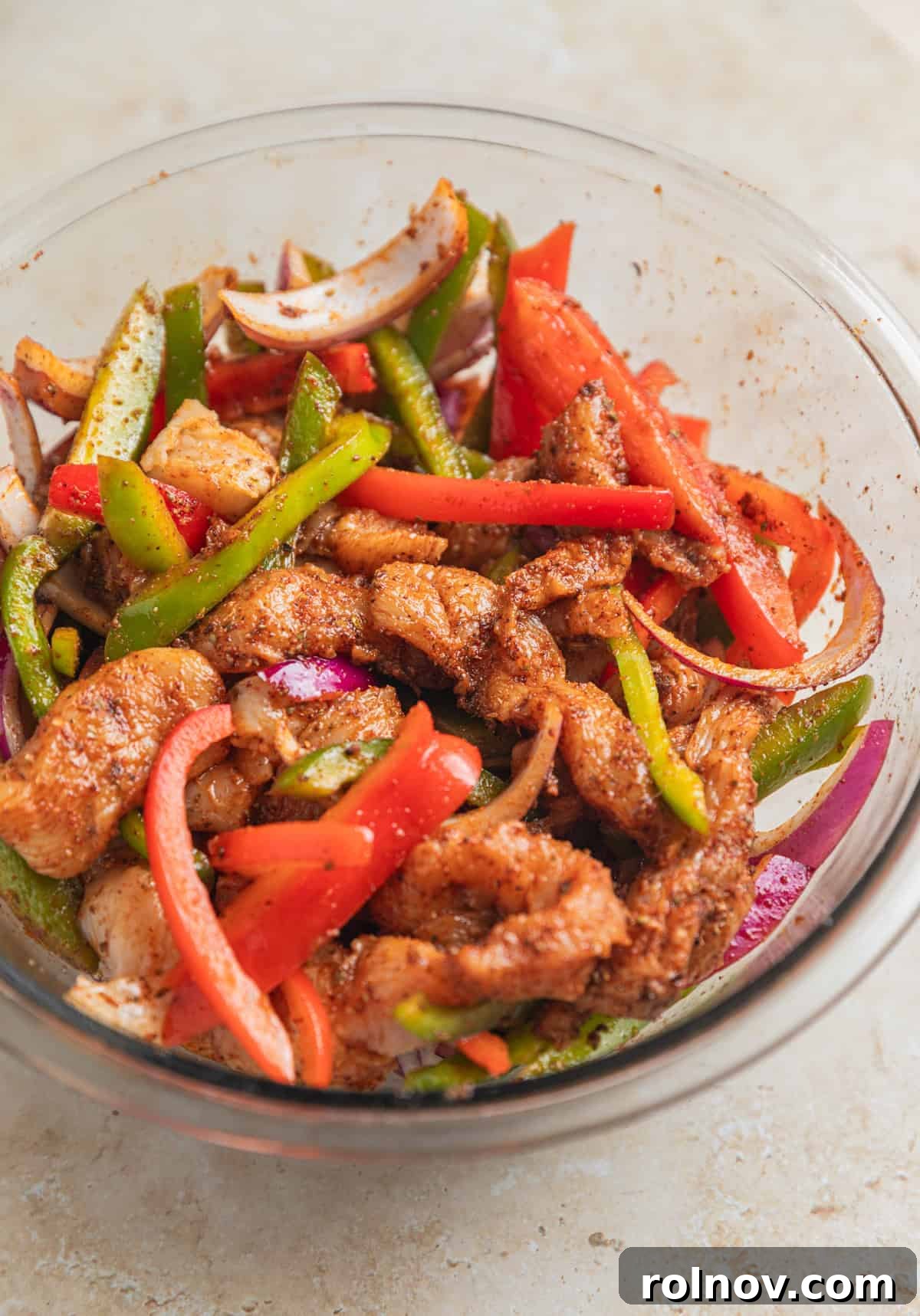 Chicken fajita mixture in bowl with marinade before being cooked.