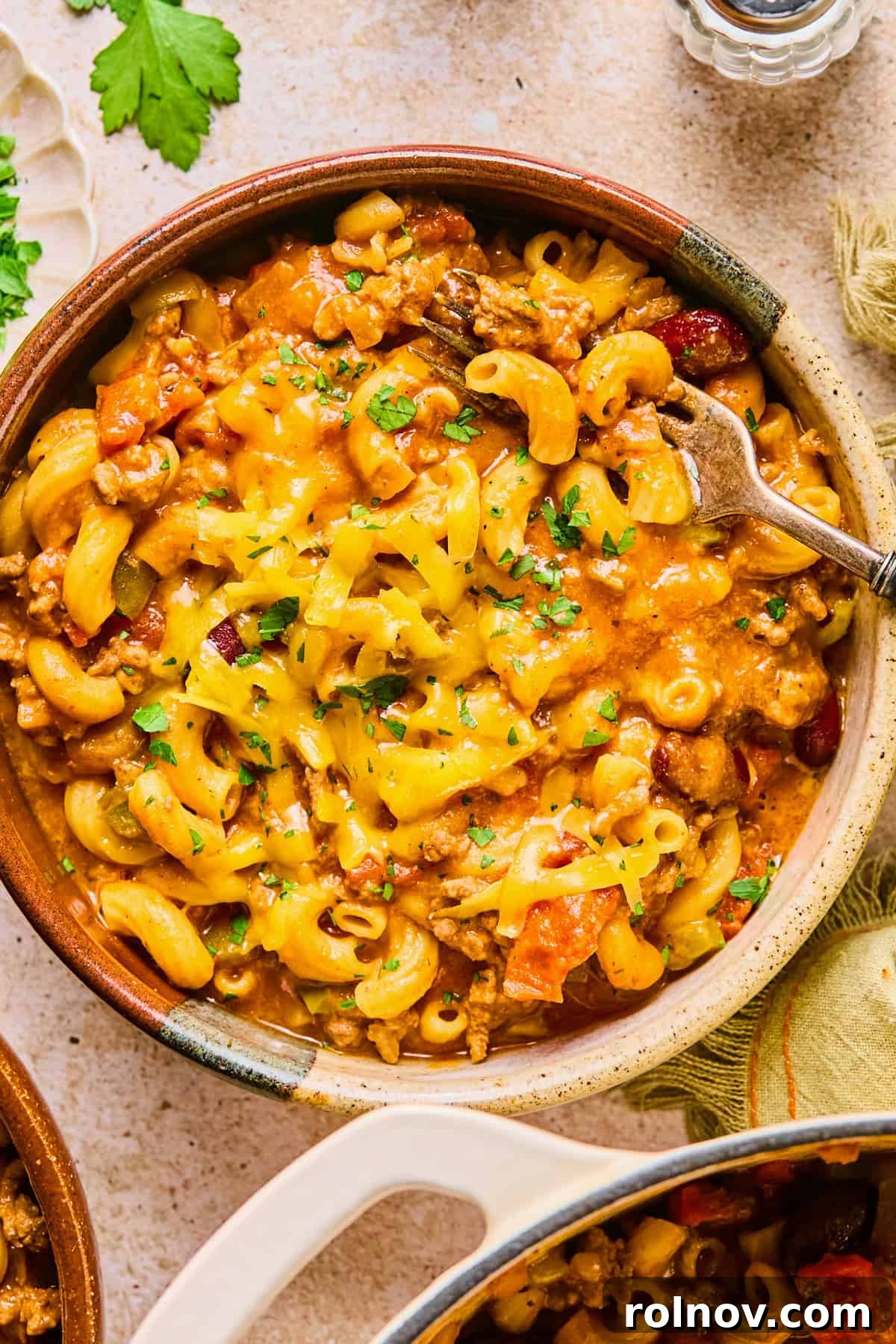 Hearty Skillet Chili Mac 13 A beautifully presented bowl of One Pot Chili Mac and Cheese, generously topped with fresh shredded cheese and a sprinkle of parsley, ready to be enjoyed.