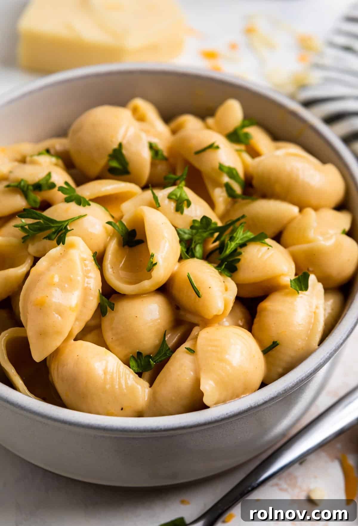 Foolproof Instant Pot Mac and Cheese 2 A steaming bowl of creamy Instant Pot Mac and Cheese shells, garnished with fresh chopped parsley.