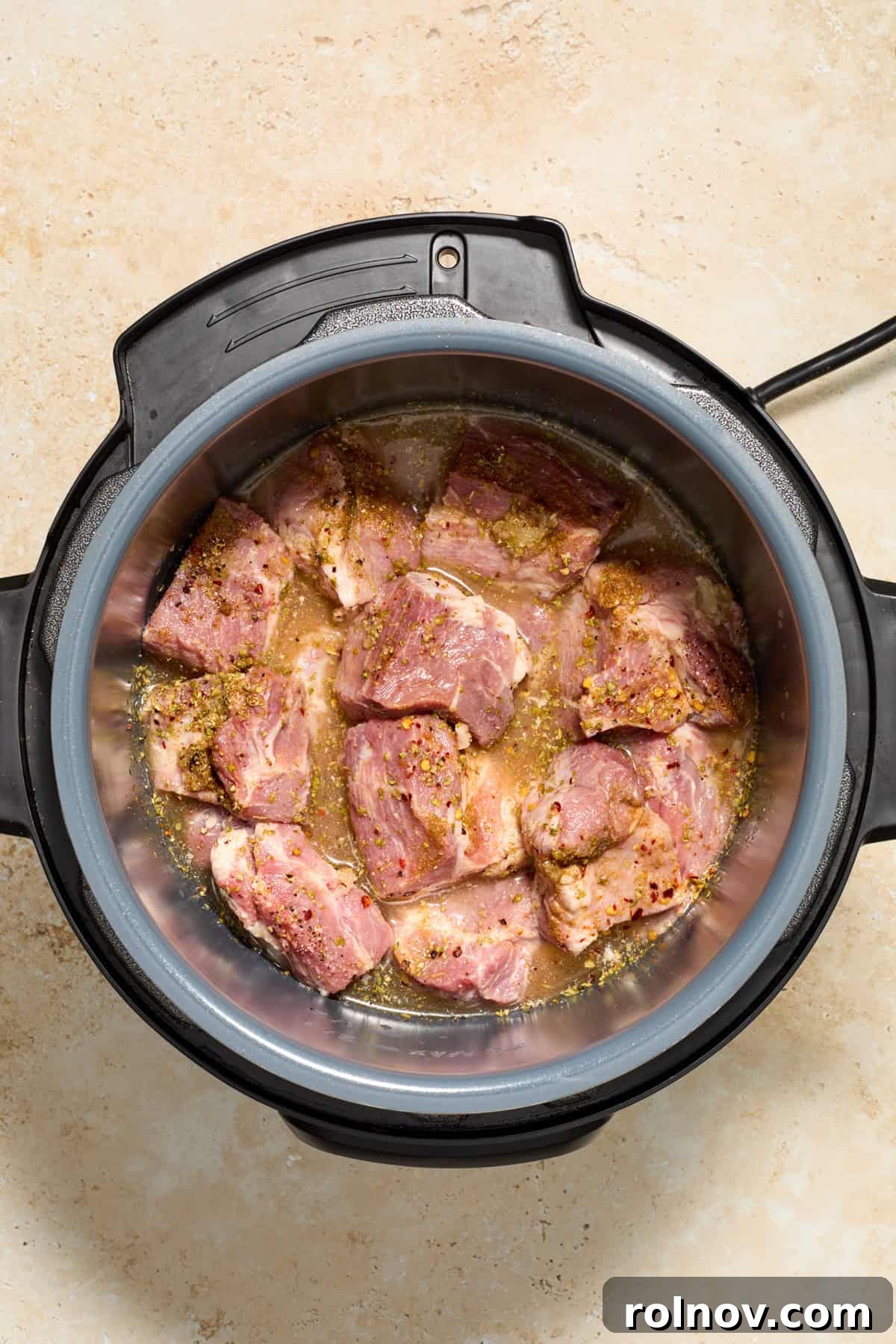 Lightning-Fast Crispy Instant Pot Carnitas 5 Instant Pot with pork, broth and seasoning.