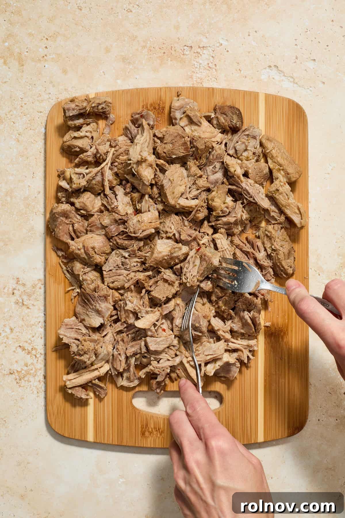 Lightning-Fast Crispy Instant Pot Carnitas 7 Pork carnitas being shredded on cutting board with two forks.