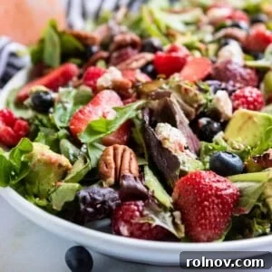 Berries and pecans delicately arranged over a bed of fresh green salad, highlighting the vibrant colors and appealing textures of the dish.