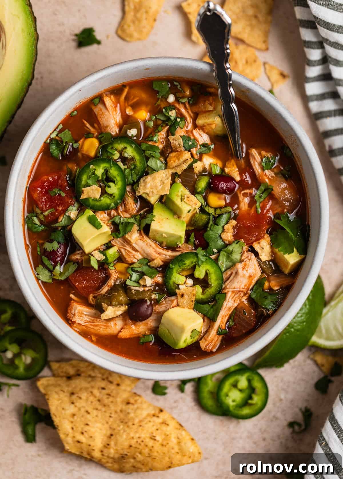 Ultimate Instant Pot Chicken Tortilla Soup 2 A beautifully garnished bowl of Instant Pot Chicken Tortilla Soup, topped with fresh cilantro, crispy tortilla chips, sliced jalapeños, and a swirl of sour cream, showcasing its rich texture and vibrant colors.
