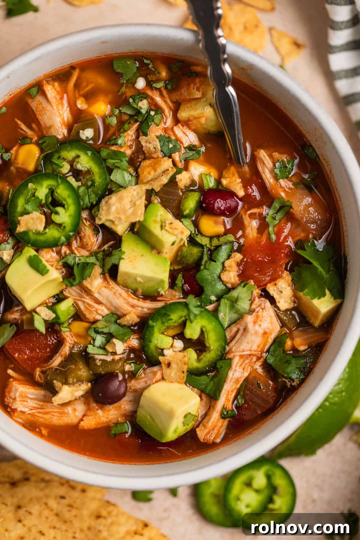 Ultimate Instant Pot Chicken Tortilla Soup 11 A vibrant bowl of Instant Pot Chicken Tortilla Soup generously topped with creamy avocado slices, crispy tortilla chips, and fresh cilantro, ready to be enjoyed.