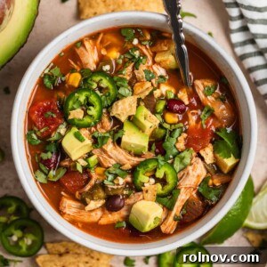 Overhead view of bowl that has chicken soup with beans, peppers, corn, etc.