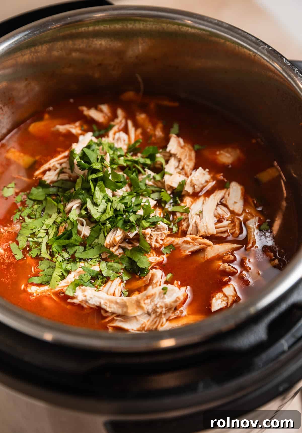 Ultimate Instant Pot Chicken Tortilla Soup 9 Shredded chicken and cilantro added to Instant Pot with soup.