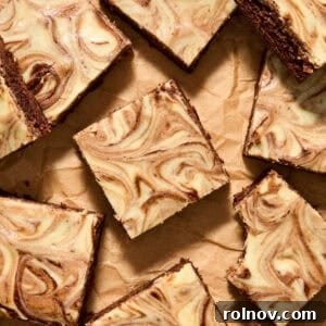Kahlua Swirled Cream Cheese Brownie Bliss 11 Kahlua brownies with cheesecake swirls on top sliced and arranged on parchment.