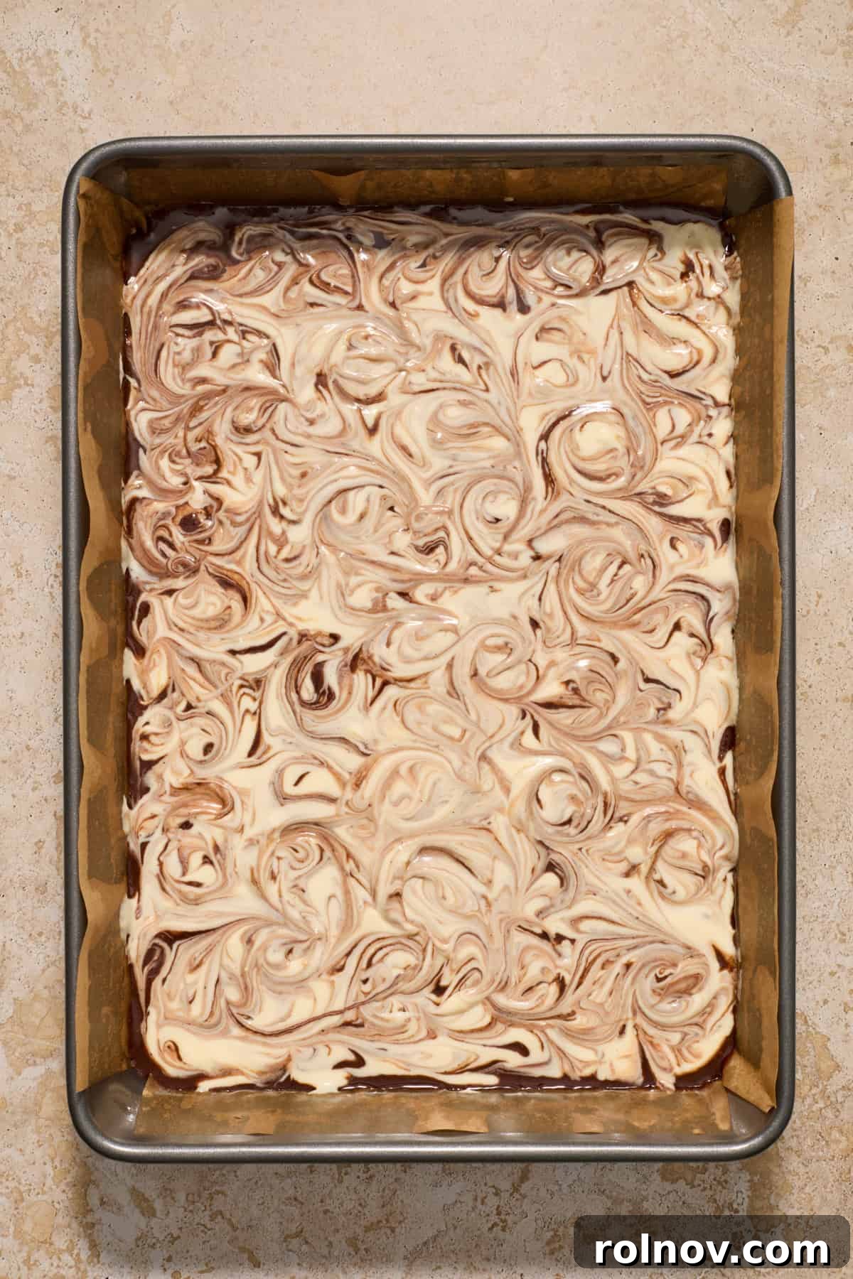 Kahlua Swirled Cream Cheese Brownie Bliss 9 Intricate swirls of cream cheese mixture blended into the rich chocolate brownie batter in a baking pan, creating a marbled effect.