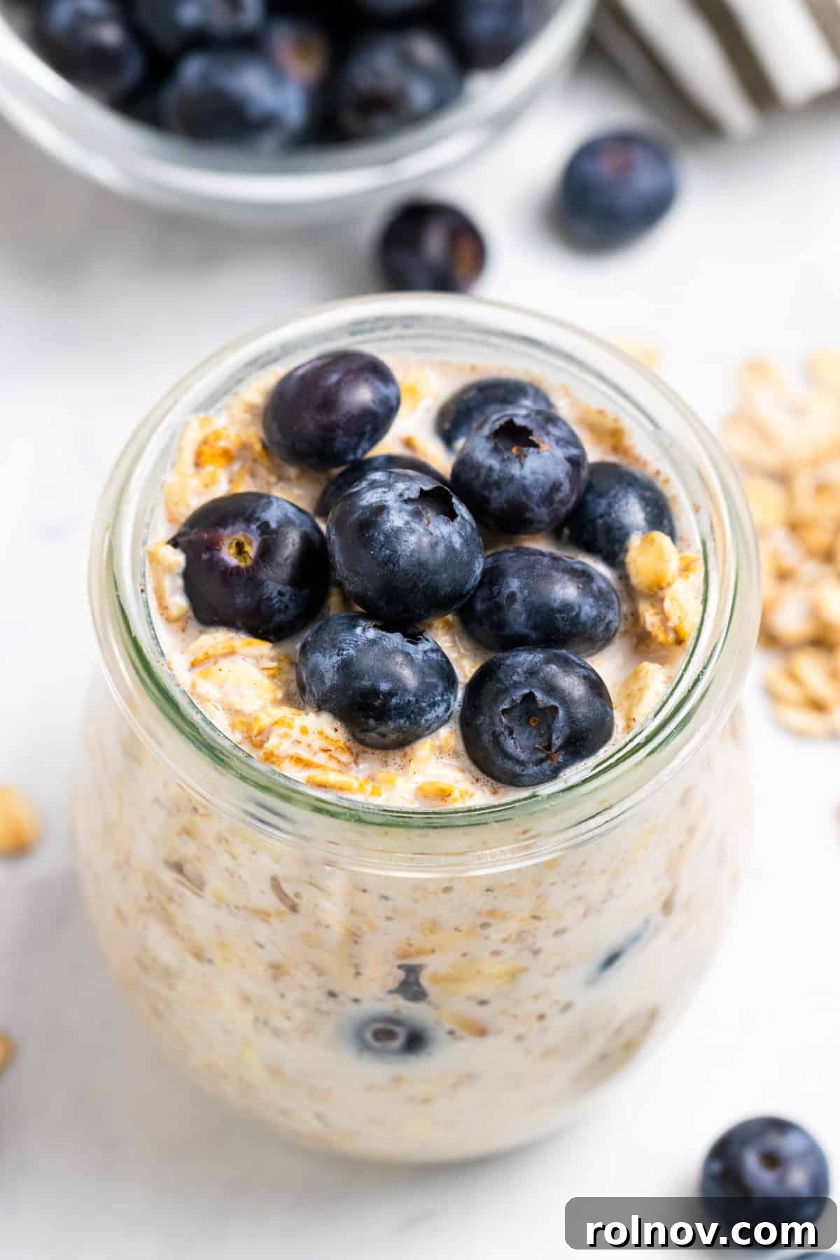 Muffin-Inspired Blueberry Overnight Oats 2 A glass jar filled with luscious Blueberry Overnight Oats, topped with fresh blueberries, ready for a delicious breakfast.