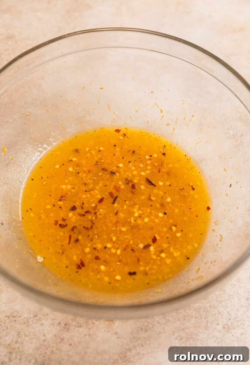 Sticky Orange Chicken One-Pan Dinner 5 Orange chicken marinade in glass mixing bowl.