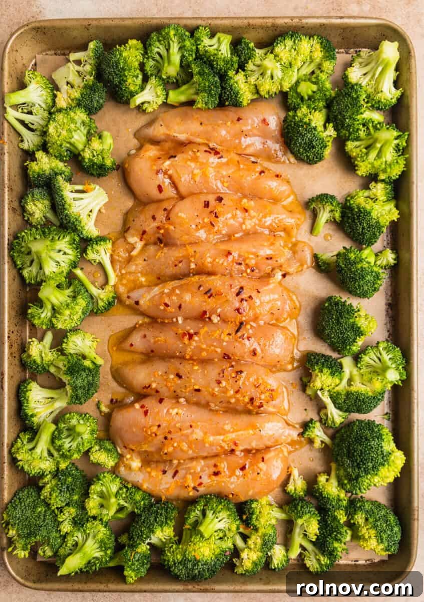 Sticky Orange Chicken One-Pan Dinner 9 Marinated orange chicken tenderloins and broccoli on sheet pan.