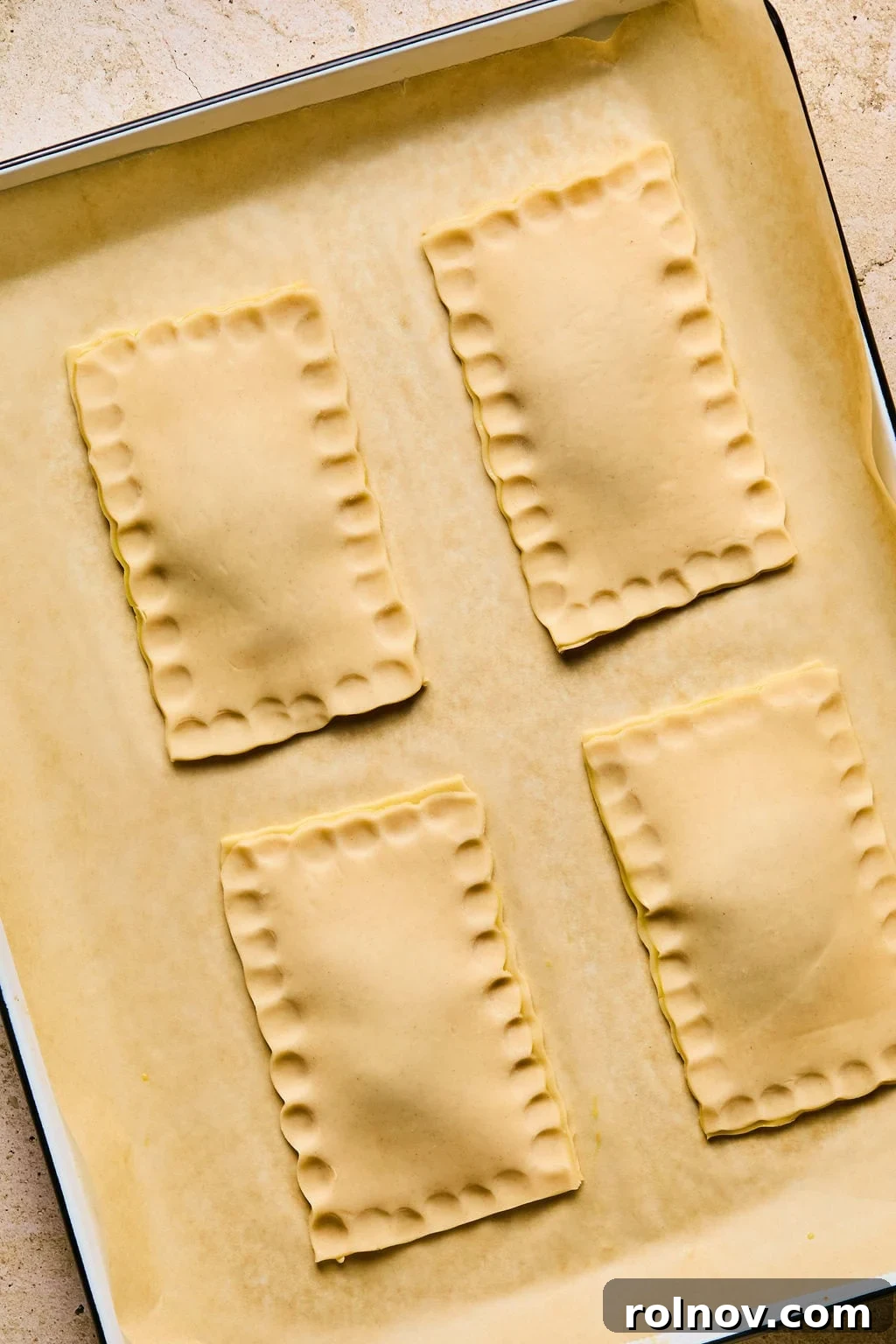 Close-up of a homemade breakfast pastry with edges securely crimped together by hand, creating a sealed pocket.