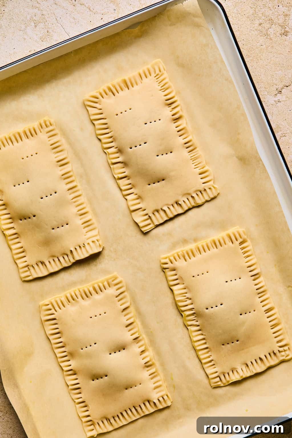 Small holes are poked into the top surface of a homemade pastry with a fork, allowing steam to escape during baking.