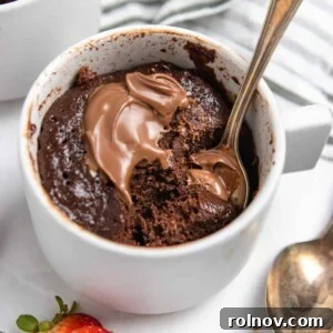 5-Minute Nutella Mug Cake 7 Flourless Nutella mug cake in mug with spoon and extra dollop of Nutella.