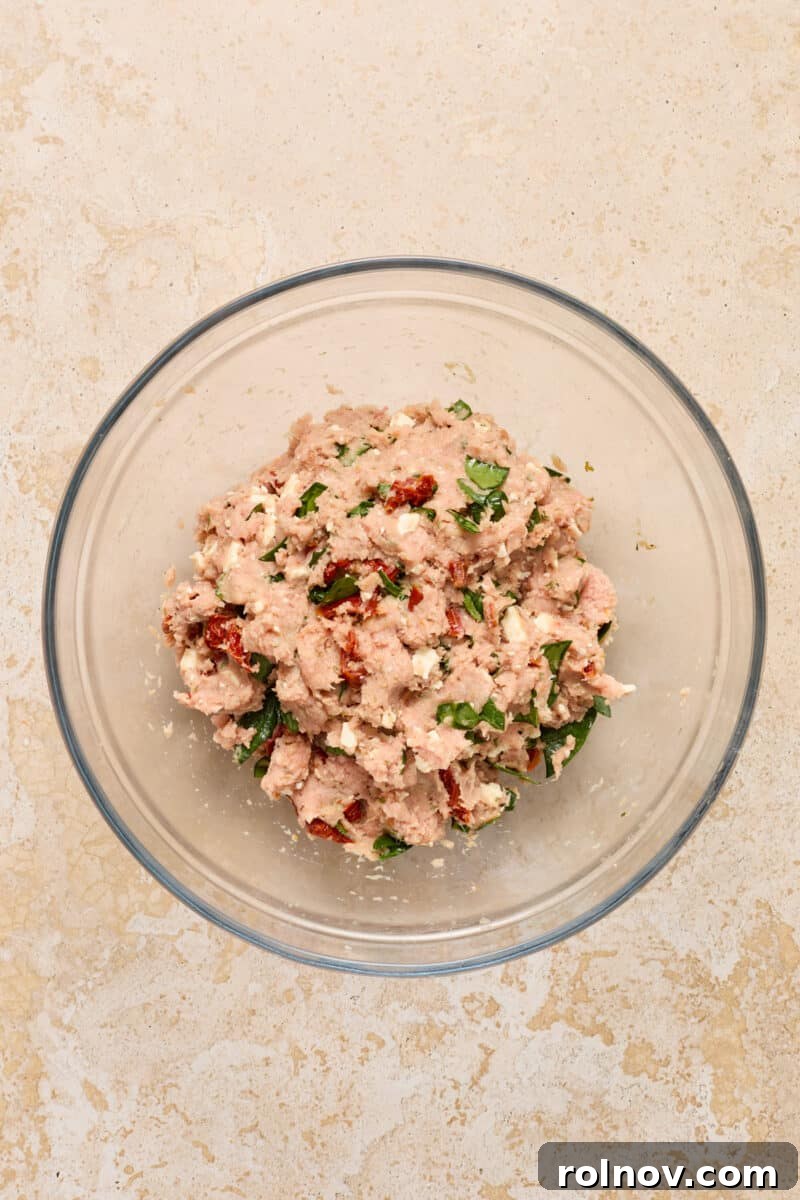 Spinach feta turkey burger mixture in glass bowl.