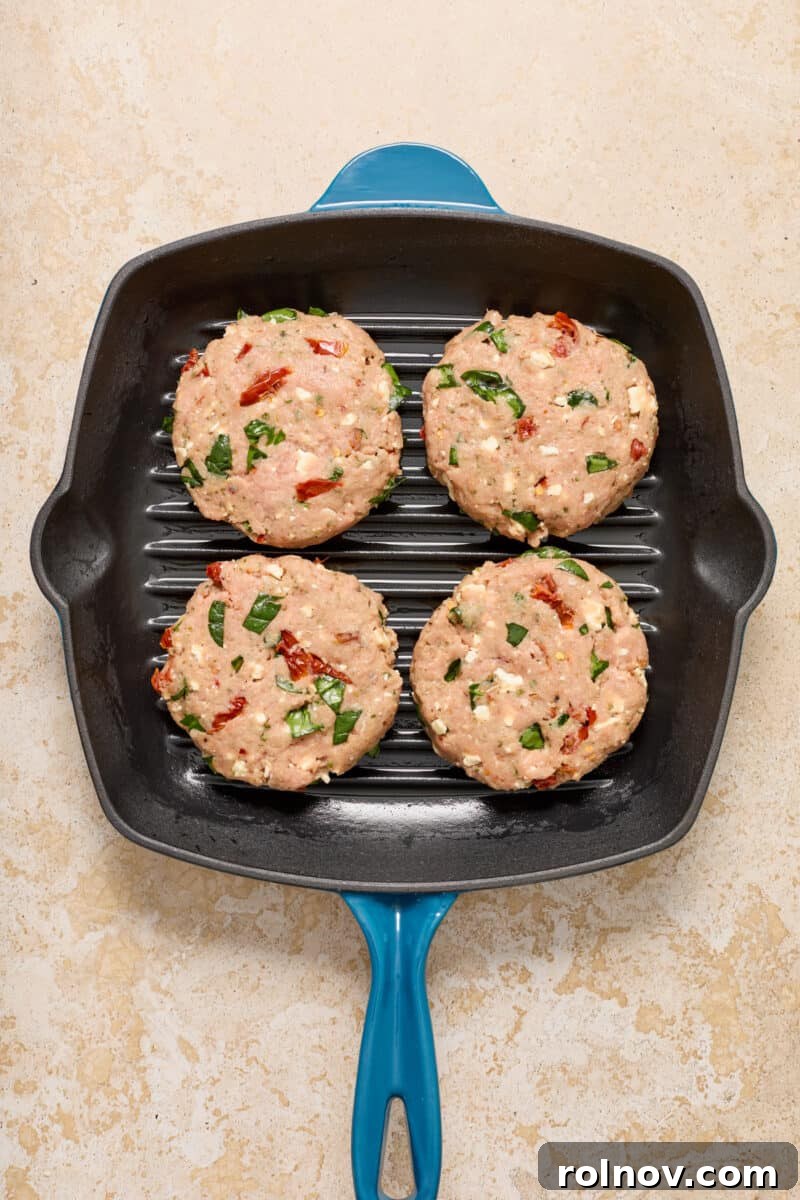 Spinach feta turkey burgers in grill skillet.