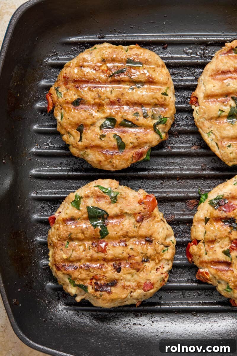 Cooked turkey burgers in grill skillet.