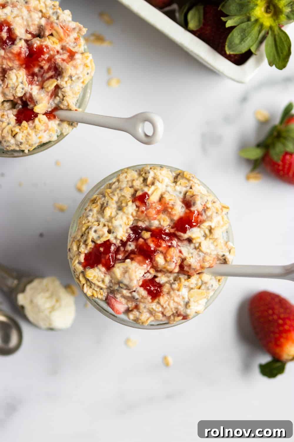 Decadent Strawberry Cheesecake Overnight Oats 3 Overhead view of jar of strawberry cheesecake overnight oats with white spoon.