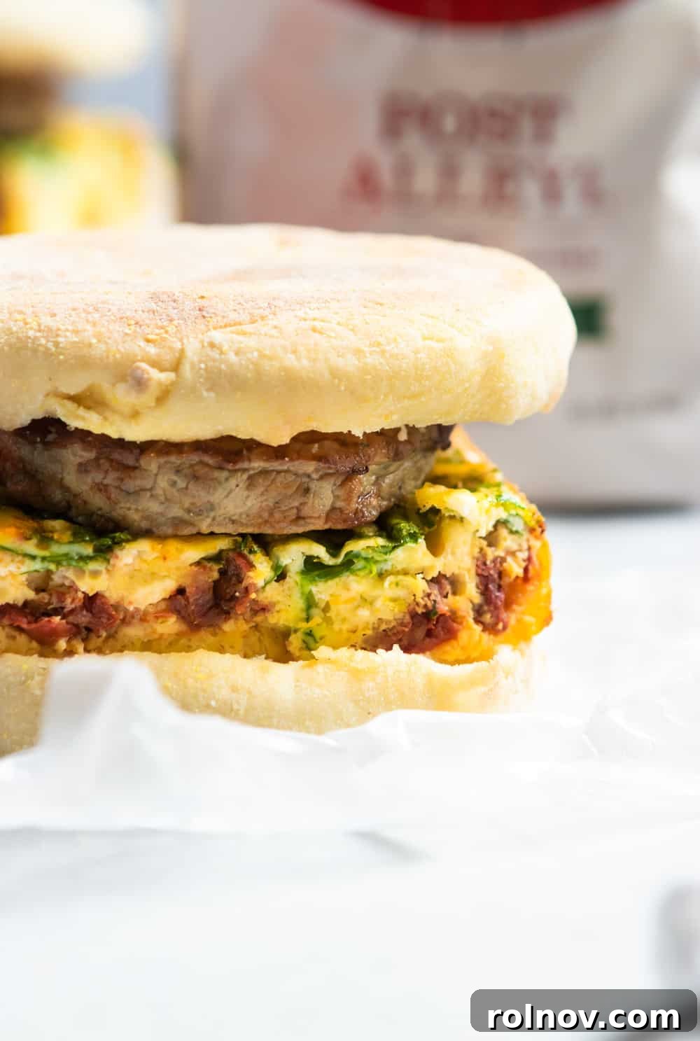Ready-to-Go Spinach Feta Breakfast Sandwiches 3 Close-up of a single Spinach, Feta, and Sun-Dried Tomato Breakfast Sandwich, showcasing its delicious layers.
