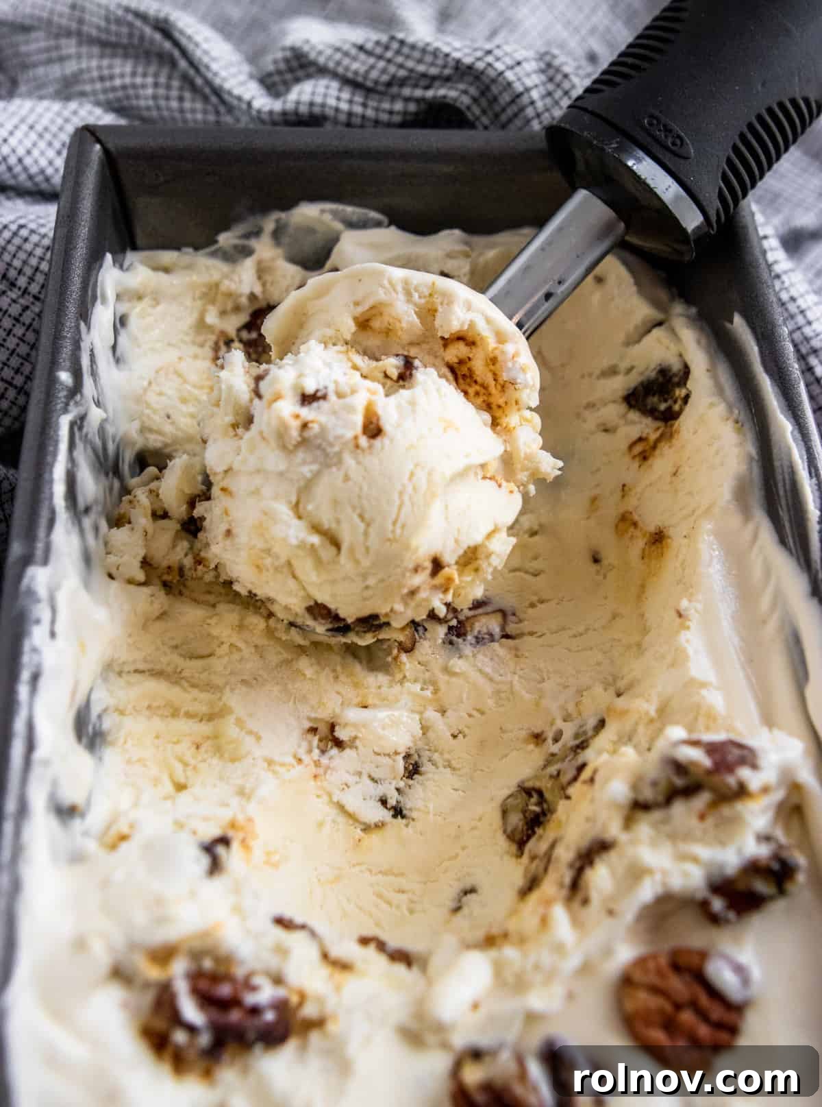 A container of freshly made no-churn butter pecan ice cream, ready to be scooped.