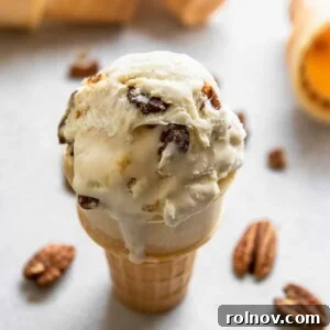 butter pecan ice cream cone with pecans beside it.